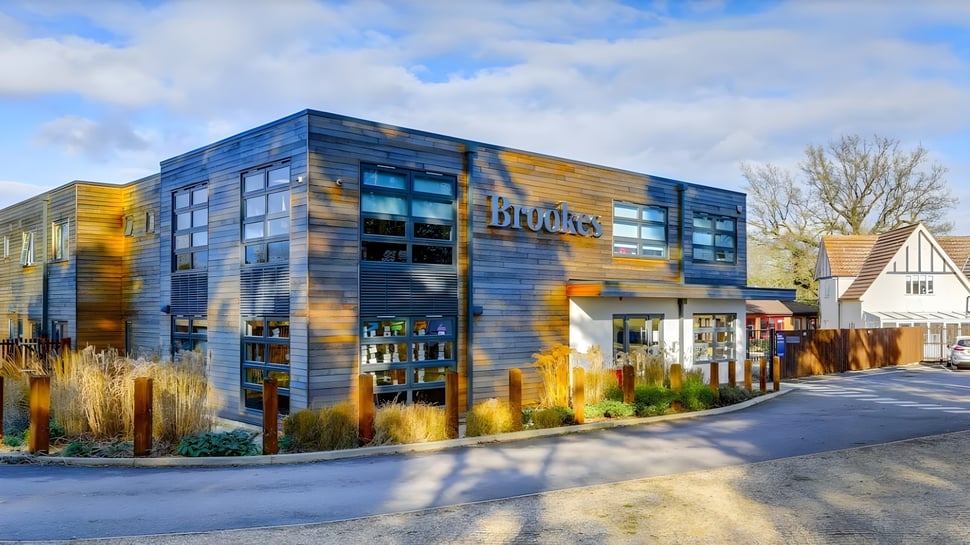 Un moderno edificio de varios pisos con elementos de fachada azules y amarillos en el campus de Brookes UK.