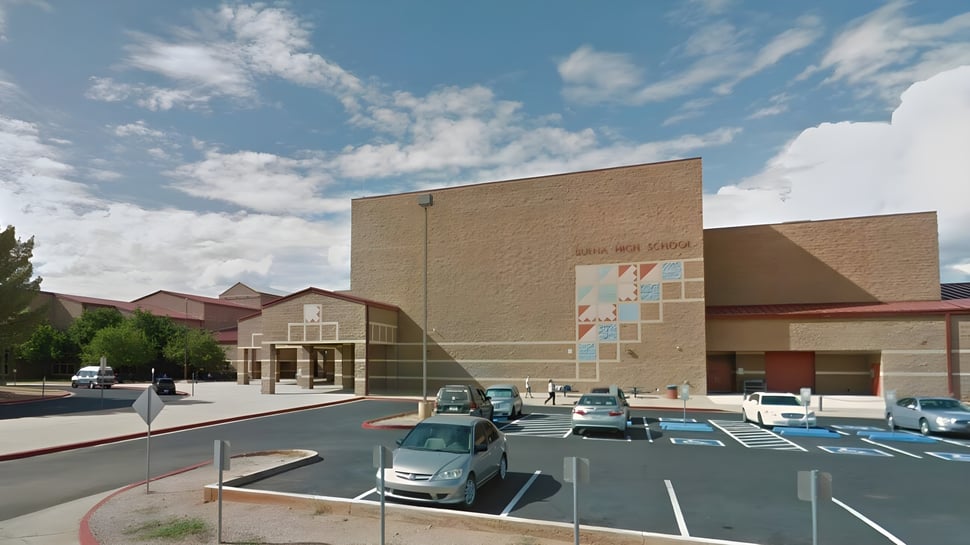 El edificio de la Buena High School con un estacionamiento en primer plano bajo un cielo azul con nubes.