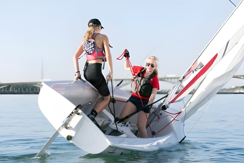 Dos mujeres en traje de baño están en un pequeño bote blanco sobre el agua cerca de Buffalo Seminary.