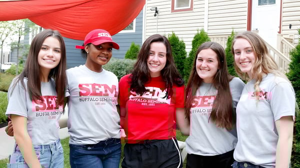 Un grupo de cinco estudiantes de Buffalo Seminary está frente a una casa con un toldo rojo.