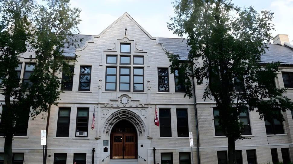 El edificio principal gótico de Buffalo Seminary está rodeado de árboles verdes.