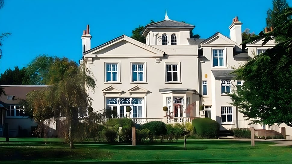 El edificio escolar de Burgess Hill Girls de varios pisos está rodeado de áreas verdes y un césped bien cuidado.