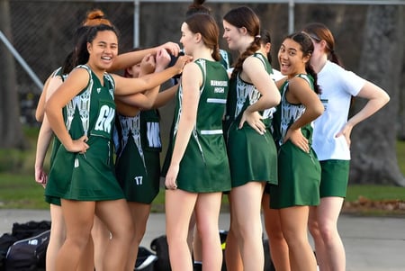 Estudiantes de la Burnside State High School celebran juntas en el campo de deportes.