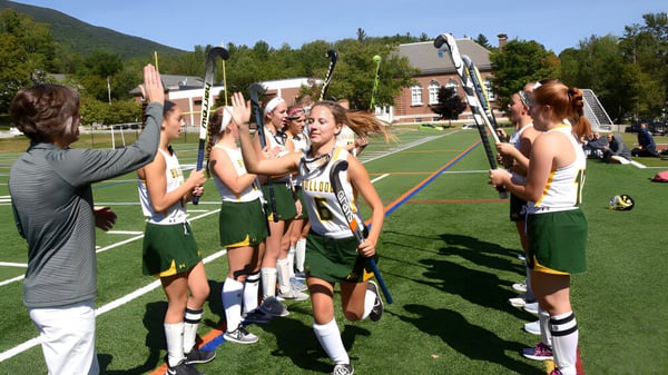 Un grupo de jóvenes atletas lleva uniformes deportivos en el campo de deportes de la Burr and Burton Academy.
