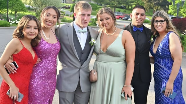 Un grupo de estudiantes de la Cabinteely Community School está al aire libre frente a árboles y edificios.