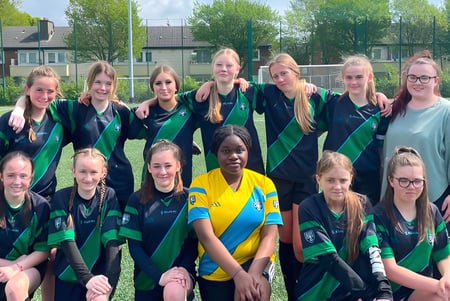 Un grupo de jugadoras de fútbol posa en el campo de deportes de la Cabinteely Community School.