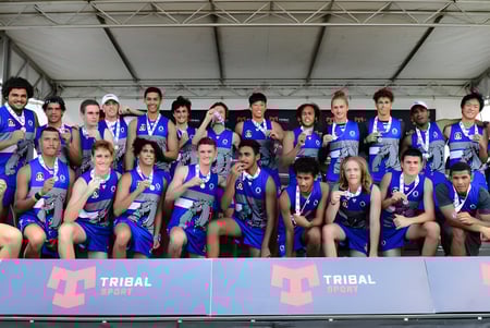 Un equipo deportivo de la Cairns State High School posa junto a una pancarta de Tribal Sport.