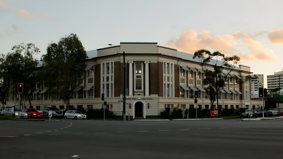 El impresionante edificio principal de la Cairns State High School está rodeado de palmeras y áreas verdes.