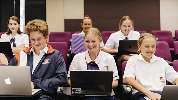Un grupo de estudiantes en el aula del Caloundra Christian College trabaja en laptops y otras tareas.