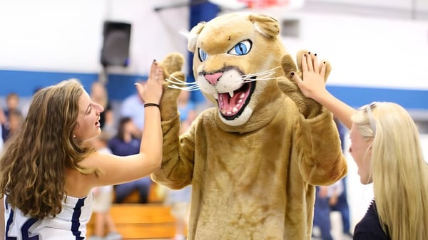 Una alumna de The Calverton School interactúa con la gran mascota en el gimnasio.