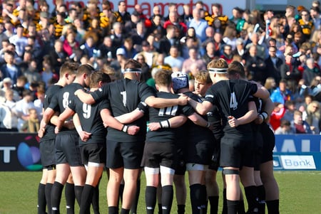 Un grupo de futbolistas del Campbell College está junto en el campo frente a una gran multitud.