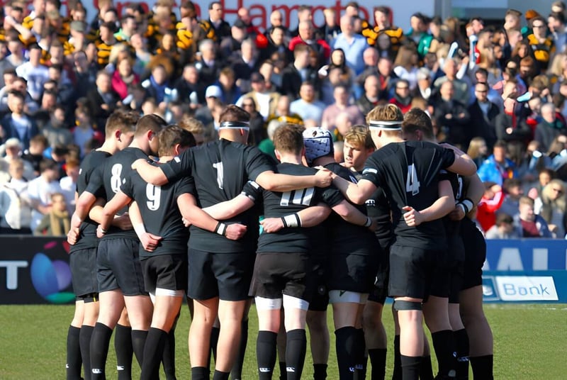Un grupo de futbolistas del Campbell College está junto en el campo frente a una gran multitud.