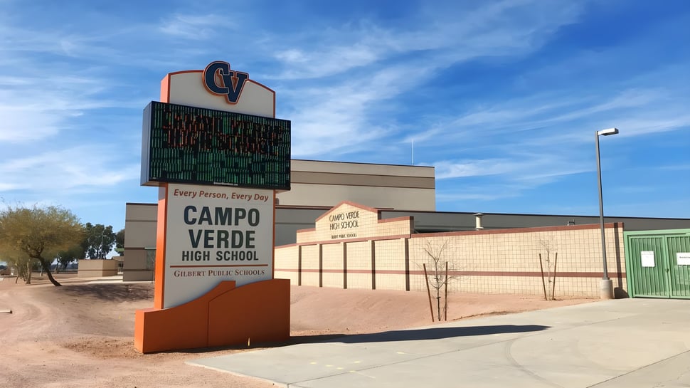 El moderno edificio de la Campo Verde High School se encuentra bajo un cielo azul con algunas nubes.