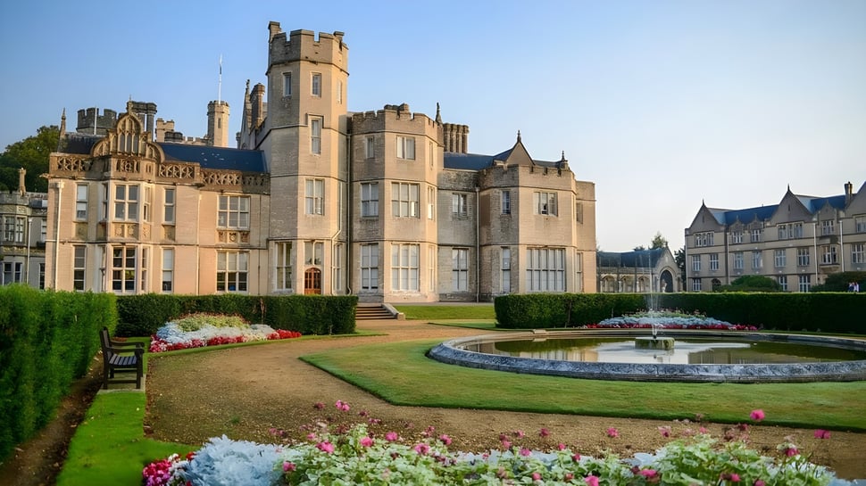 El castillo de la Canford School está rodeado de un jardín bien cuidado con fuentes y parterres de flores.