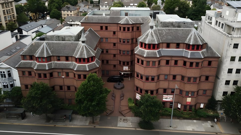 El Cardiff Sixth Form College muestra un conjunto de edificios de ladrillo rojo con torres y un entorno verde.