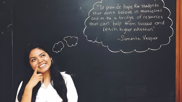 Una joven profesora está frente a una pizarra con una cita sobre la educación en la Carl Schurz High School.