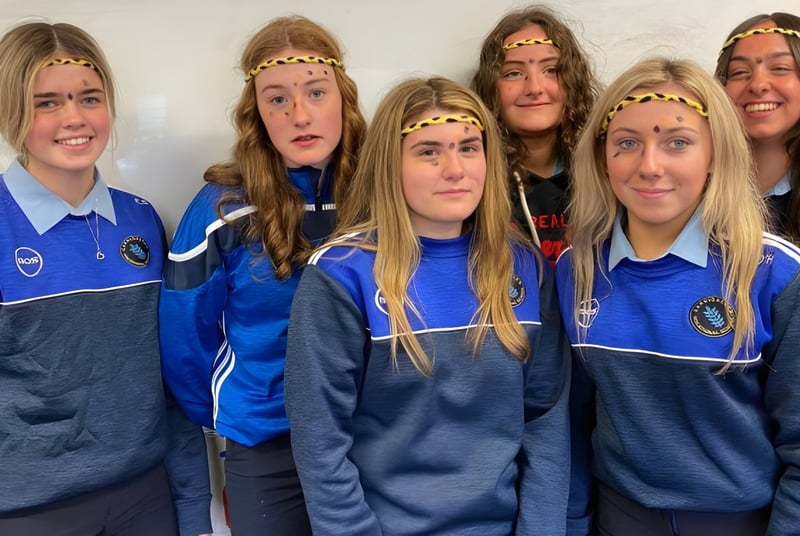 Un grupo de estudiantes de la Carrigallen Vocational School lleva uniformes azules y posa juntos con diferentes expresiones faciales.