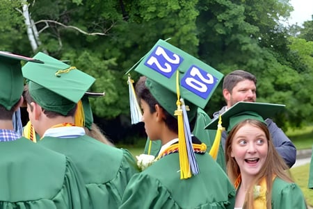 Un grupo de graduados en togas verdes está al aire libre en el campus de Castleblayney College.