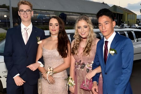 Cuatro personas bien vestidas frente a un vehículo en el terreno de la Cathedral School of St Anne & St James.