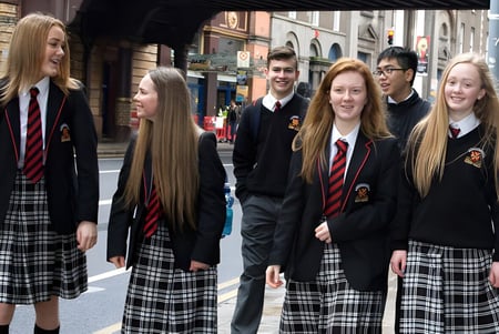 Alumnos de CBS Westland Row están en uniforme en una escena callejera con edificios históricos de fondo.