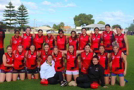 Un grupo de jugadoras de fútbol en uniforme rojo en el campo de la Central Yorke School.