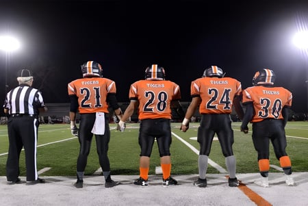 Estudiantes de la Chaffey Joint Union High School District juegan al fútbol bajo las luces del estadio.