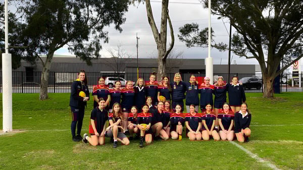 Un grupo de jóvenes atletas posan en un campo de césped en el campus del Charles Campbell College.