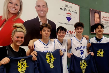 Un grupo de jóvenes jugadores de baloncesto posan frente a un banner con candidatos políticos en el campus de la Chateauguay Valley Regional High School.
