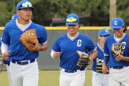 Un grupo de estudiantes jugando béisbol en uniformes azules está en el campo de béisbol del Chino Valley Unified School District.