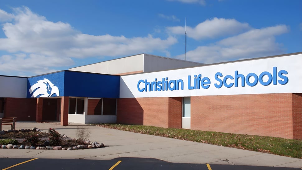 El edificio de la Christian Life School con fachada de ladrillo y el nombre de la escuela claramente visible bajo un cielo azul.