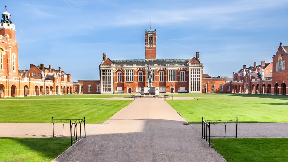 El edificio histórico de ladrillo con una alta torre en el campus de la Christ's Hospital School está rodeado de césped verde y un camino de piedra.