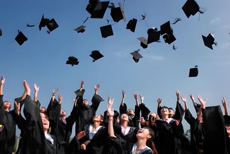 Los graduados del Clark County School District lanzan sus sombreros al aire durante la ceremonia de graduación.