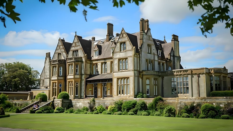 La mansión victoriana en el terreno de la Clayesmore School está rodeada de vegetación verde y un césped bien cuidado.