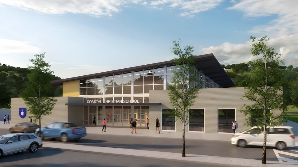El moderno edificio de varios pisos de la Coastal Christian School con fachada de vidrio se encuentra en un entorno urbano con árboles y vehículos estacionados.