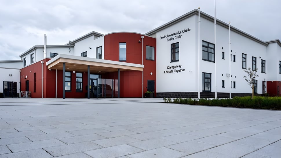 El moderno edificio de varios pisos con pared de acento roja en el campus de la Coláiste Bhaile Chláir.