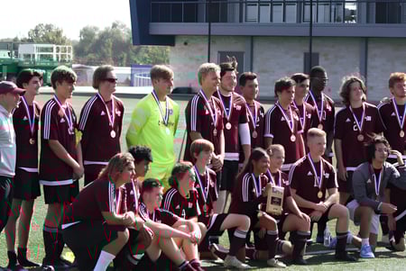 Un grupo de jóvenes futbolistas posa juntos en el campo de fútbol de la Coláiste Bhaile Chláir.
