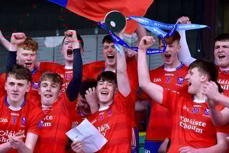 Un grupo de estudiantes de la Coláiste Choilm celebra con un trofeo en mano su victoria.