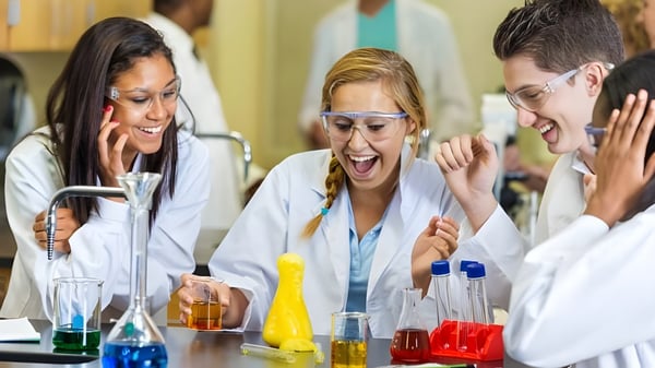 Estudiantes de la Coláiste Éamann Rís discuten y experimentan juntos en un laboratorio.