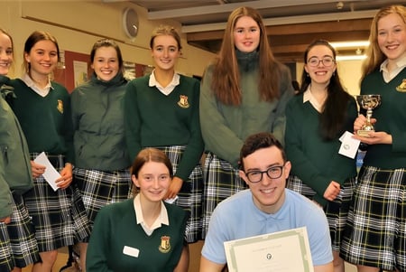 Un grupo de estudiantes de Coláiste Íosagáin posa junto con un trofeo en la escuela.