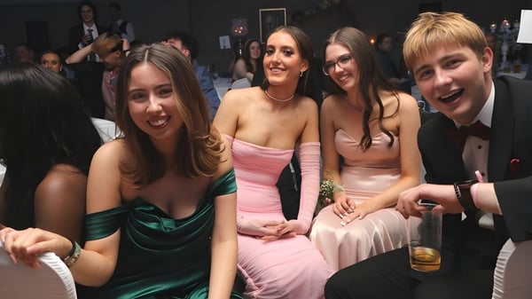 Un grupo de jóvenes en ropa formal en un evento en el campus de Coláiste Íosagáin.