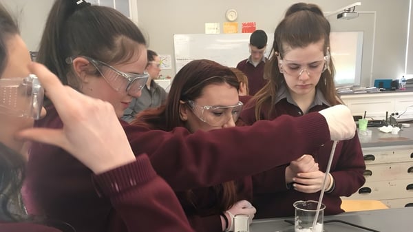 Estudiantes de Colaiste Mhuire (Tourmakeady) realizan juntos una actividad de laboratorio en una mesa.