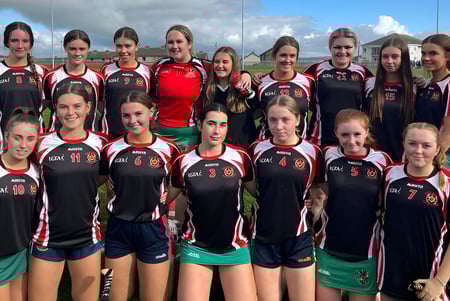 Un grupo de jóvenes deportistas posan en el campo de deportes de la Colaiste Muire (Cobh) bajo un cielo nublado.