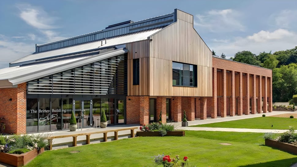 El moderno edificio de varios pisos de Coláiste Pobail Acla está rodeado de césped bien cuidado y árboles.