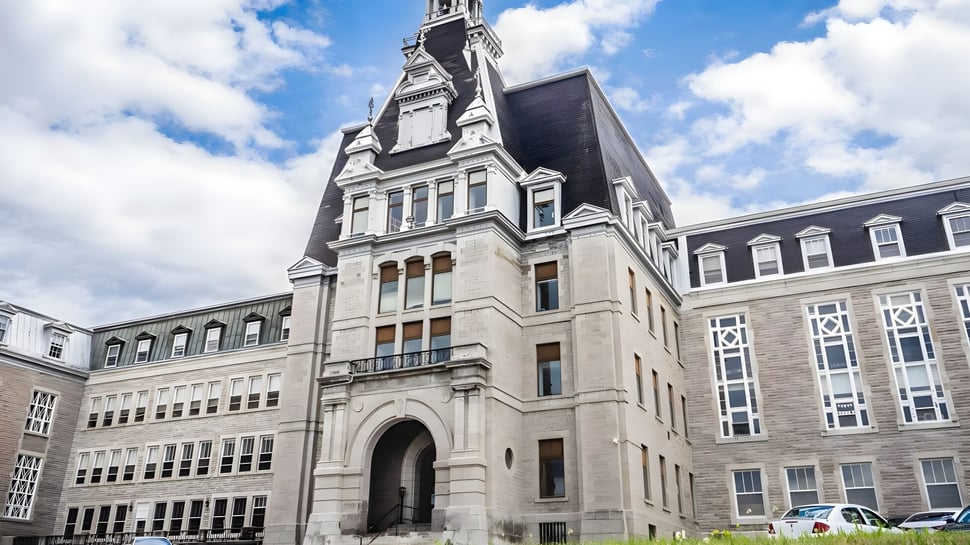 El histórico edificio principal del College Bourget con elaborada arquitectura de piedra bajo un cielo nublado en un entorno urbano.