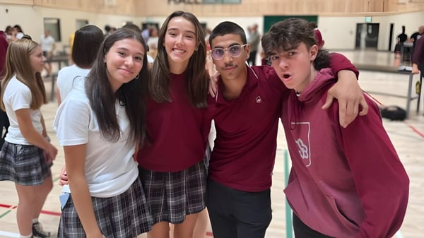 Un grupo de estudiantes sonrientes está junto en el pasillo del College Saint-Bernard.