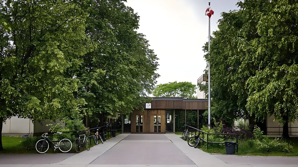 Un camino pavimentado con bicicletas y árboles en el campus de la Colonel By Secondary School.
