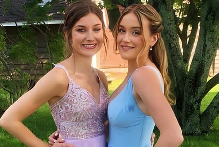 Dos estudiantes están juntos en el área verde del campus de la Colonel Gray High School.