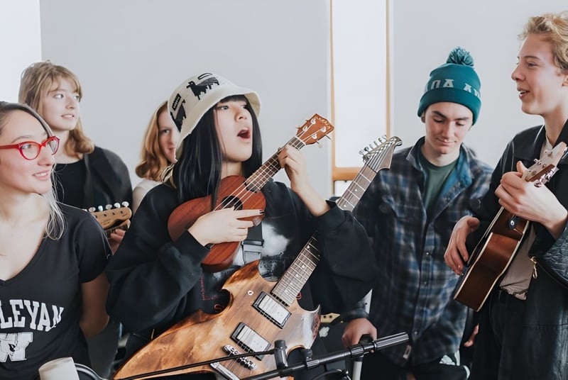 Estudiantes de la Colorado Rocky Mountain School se reúnen con instrumentos musicales en una sala.