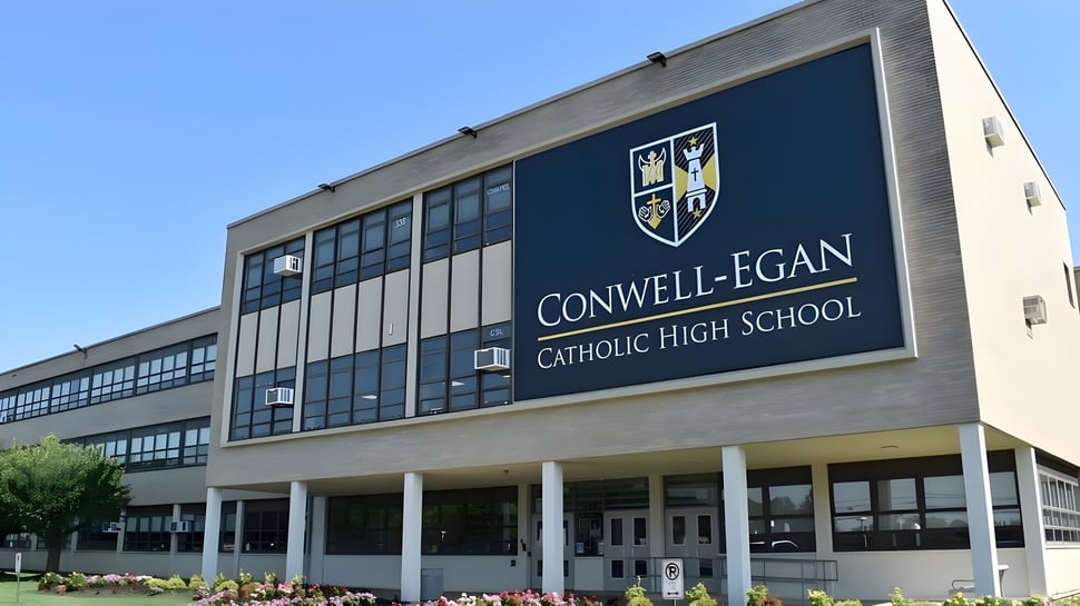 El edificio escolar de varios pisos de la Conwell-Egan Catholic High School con un letrero y logo bien visibles.