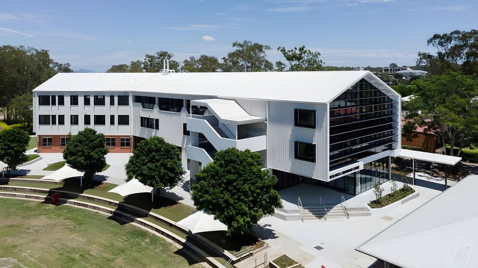 El moderno edificio de varios pisos de la Corinda State High School está rodeado de árboles y áreas verdes.